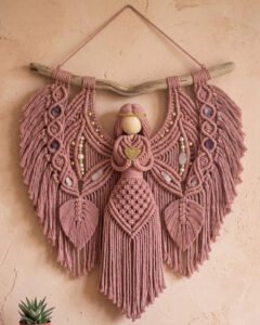 Finished dusty rose angel macramé wall hanging pattern on driftwood with wings and flowing skirt