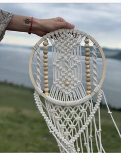Finished beaded dreamcatcher macramé pattern with wooden hoop, bead columns, and knotted fringe