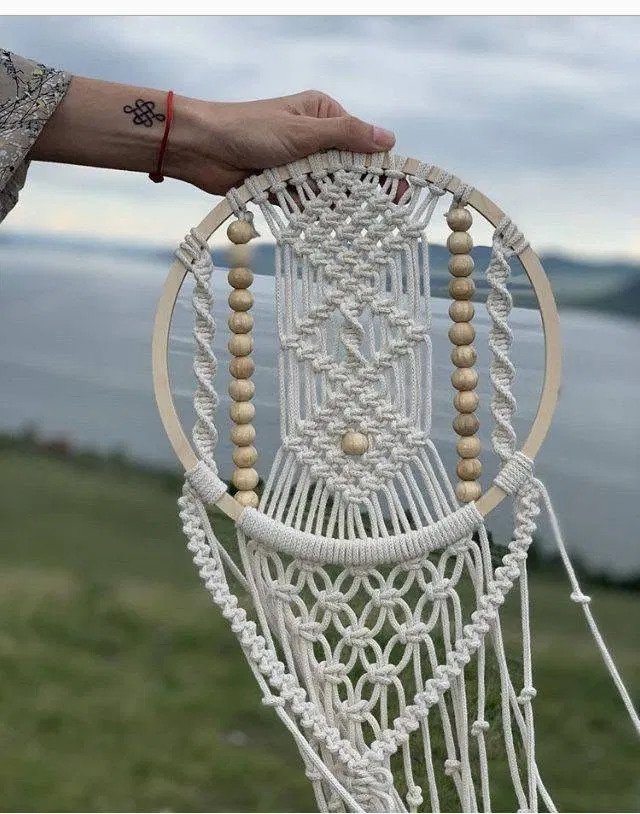 Finished beaded dreamcatcher macramé pattern with wooden hoop, bead columns, and knotted fringe