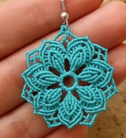Finished lotus mandala earrings macramé pattern in turquoise waxed cord held in hand