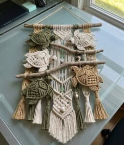 Finished sea turtle macramé pattern wall hanging with five knotted turtles on driftwood